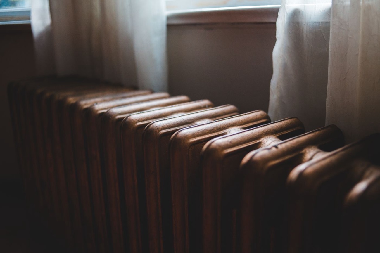 Radiateur en fonte ancien aux reflets cuivrés dans une maison de caractère